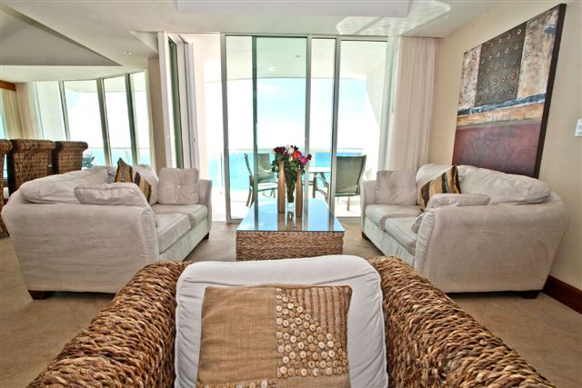 Another view of the extra large great room with contemporary furniture, ocean view and open to modern kitchen