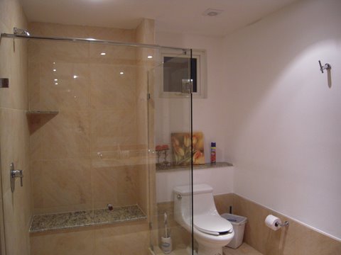 ultra luxury bathroom with sit down shower, granite counters, and fine porcelain tiles