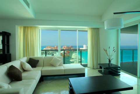 Another view of the extra large great room with contemporary furniture, ocean view and open to modern kitchen