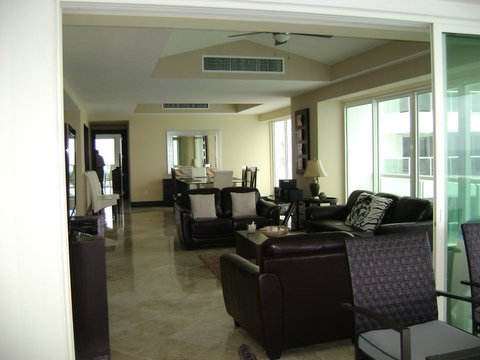 Another view of the extra large great room with contemporary furniture, ocean view and open to modern kitchen
