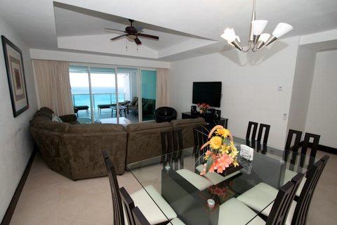 Another view of the extra large great room with contemporary furniture, ocean view and open to modern kitchen