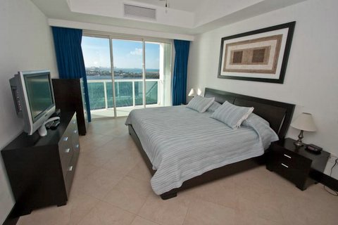 master bedroom with lagoon and city view terrace, full bath, walk in closet and 32 inch lcd tv