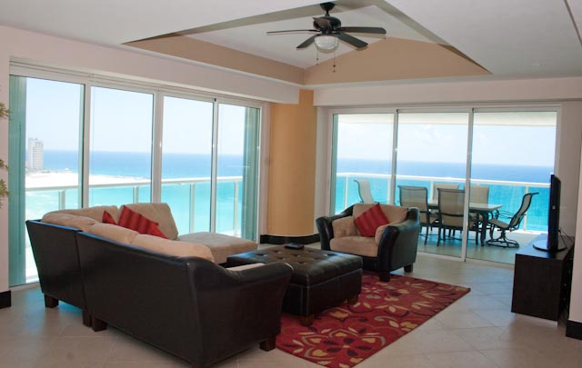Another view of the extra large great room with contemporary furniture, ocean view and open to modern kitchen