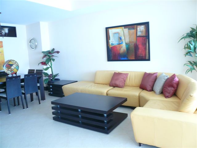 Another view of the extra large great room with contemporary furniture, ocean view and open to modern kitchen