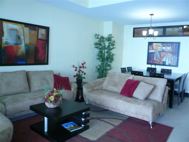 Another view of the extra large great room with contemporary furniture, ocean view and open to modern kitchen