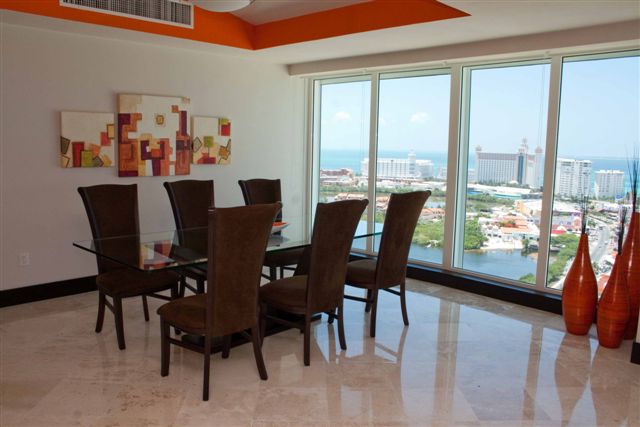 Another view of the extra large great room with contemporary furniture, ocean view and open to modern kitchen